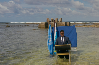 Tuvalu’s Foreign Minister Simon Kofe delivers his COP26 statement standing in the ocean in Funafuti, Tuvalu.