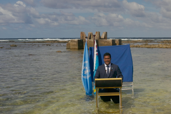 Tuvalu Foreign Minister Simon Kofe addresses COP26 in 2021 standing in the rising seas threatening his island, which could be lost beyond 1.5 degrees of warming.