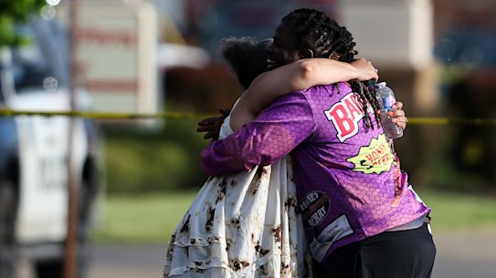 People hug outside the scene after a shooting at a supermarket on Saturday, May 14, 2022, in Buffalo, New York. 