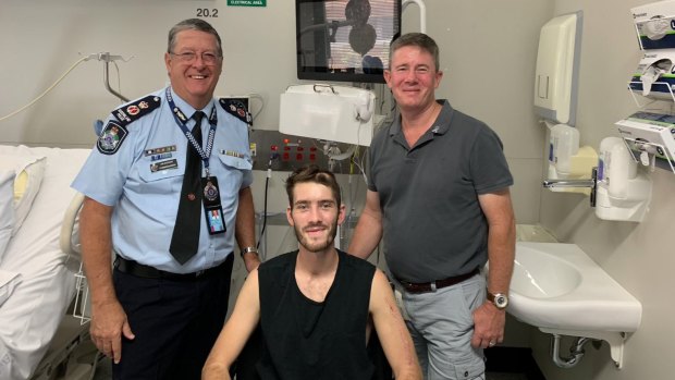 Queensland Police Constable Peter McAulay in hospital with his father Mike and former police commissioner Ian Stewart.