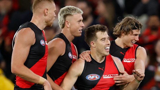 Zach Merrett with Essendon teammates.