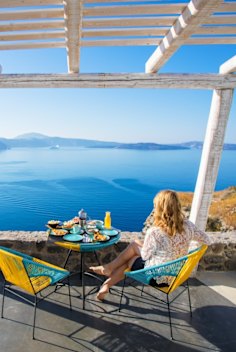 Woman enjoying breakfast with beautiful view over Santorini
iStock image for Traveller. Reuse permitted.
Greek breakfast, in Greece (Greek Islands)