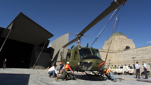 A picture from 2001 showing an helicopter from the Royal Australian Air Force that flew in Vietnam in 1966 being transported by truck to the then-new Anzac Hall at the rear of the Memorial.