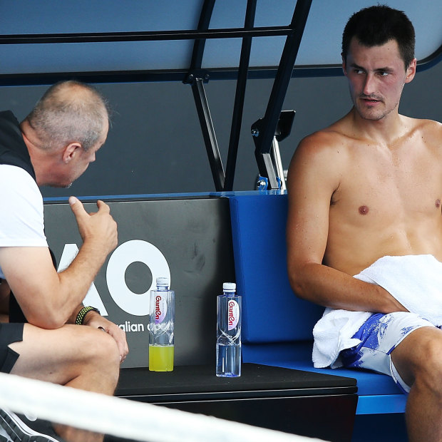 John Tomic talks to his son during the 2018 Australian Open.