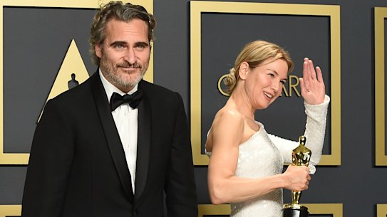 Joaquin Phoenix and Renee Zellweger pose in the press room with their Oscars.