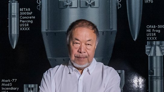 Ai Weiwei poses next to his new 30-metre-wide work History of Bombs, built from more than a million toy bricks, which is part of an exhibition and live performance exploring the intertwined histories of China and Britain.