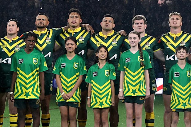 Kangaroos players stand together for the national anthem.