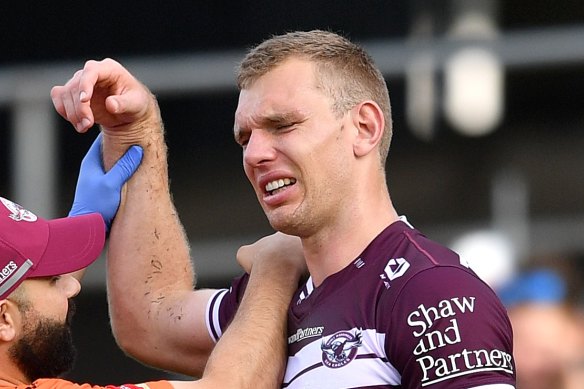 Tom Trbojevic grimaces while having his shoulder assessed after injuring it against the Titans.