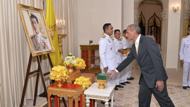 Craig Challen receives the Member of the Most Admirable Order of the Direkgunabhorn in front of a portrait of Thailand's King Maha Vajiralongkorn Bodindradebayavarangkun.