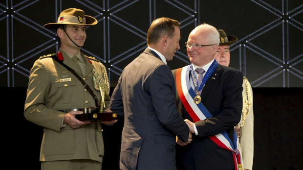 Villers-Bretonneux mayor Patrick Simon receives his honorary AO in 2015 from then Australian prime minister Tony Abbott.