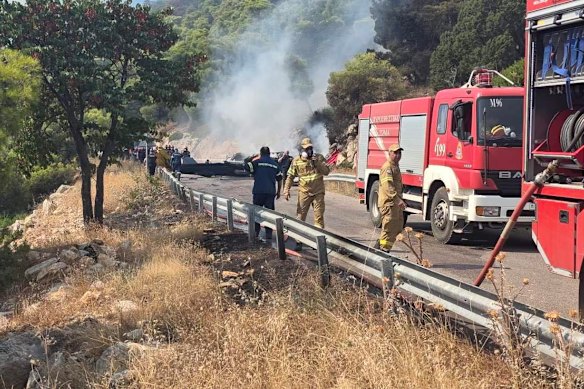 Firefighters work at the site where firefighting helicopters crashed on Sunday.