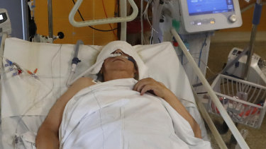 A COVID-19 patient lies on a bed in an intensive care unit.