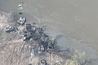 An aerial view of burnt vehicles and the remains of what appears to be a makeshift bridge across the Siverskyi Donets River, eastern Ukraine. 