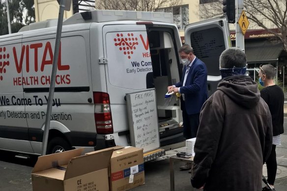 Ricky Nixon on Bay Street in Port Melbourne in 2020 selling PPE alongside his health company van. 