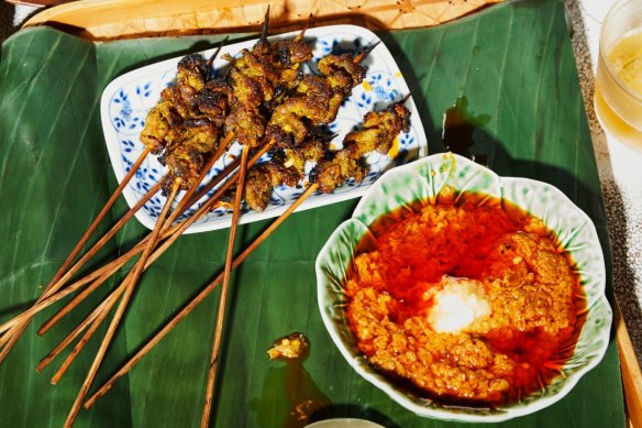 Satay sauce served alongside pork satay skewers.