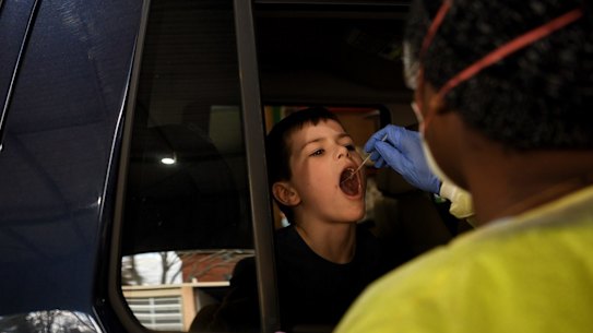 Seven year old Owen from Petersham reacts to having a COVID-19 test by a NSW Health employee who are testing people for coronavirus COVID-19 at the Summer Hill drive-through Clinic NSW. 11th August, 2020. Photo: Kate Geraghty