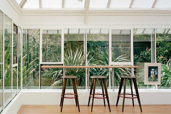 There’s a simple timber bench suspended from the ceiling, aligned to the mullions set into the glazed windows.