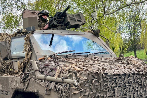 A member of the 80th Airborne Assault Brigade on a Bushmaster.