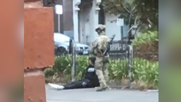 A counter-terrorism officer stands guard over the arrested man.