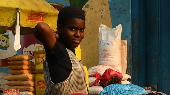 Men and women at their stalls in a market on the streets of Kinshasa. General elections have been delayed for a week amid unrest.