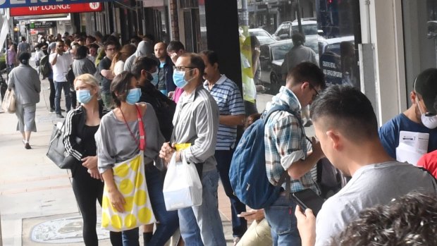 The nation must decide its best path forward: People lining up at a Centrelink office amid he COVID-19 shock.