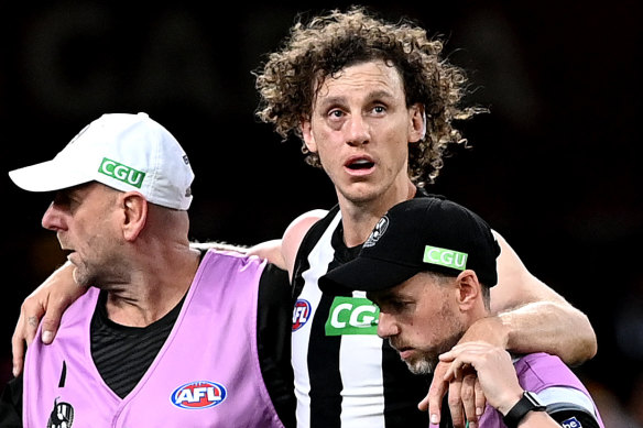 Chris Mayne is helped from the field after his collision with Patrick Cripps.