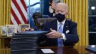 President Joe Biden signs his first executive orders in the White House.