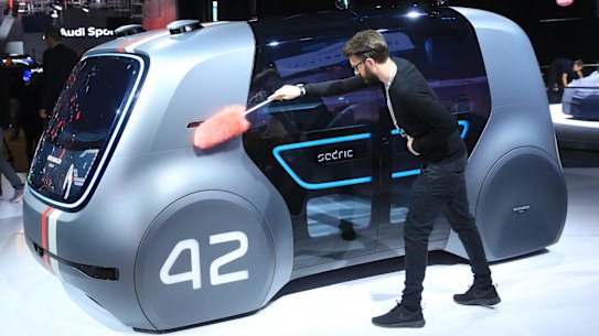 An employee dusts a VW Sedric concept electric autonomous robo-taxi ahead of the IAA Frankfurt Motor Show.