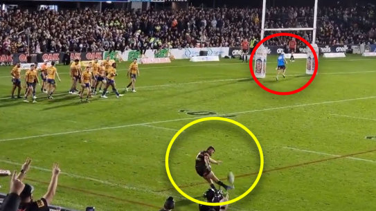 A Parramatta trainer runs in front of the goalposts as Nathan Cleary attempts a conversion attempt.