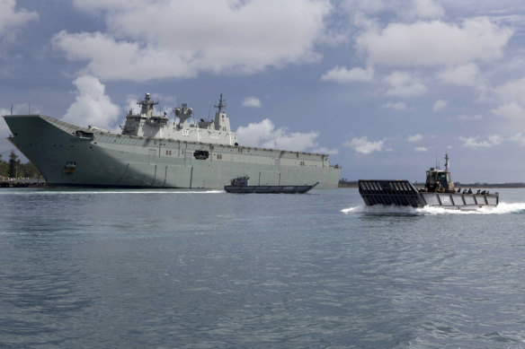 HMAS Adelaide with a  landing craft.