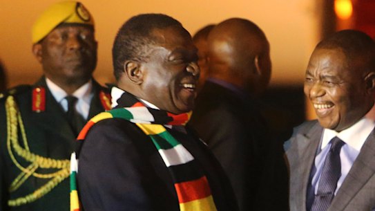 Zimbabwean President Emmerson Mnangagwa, left, is greeted as he arrives at Robert Mugabe International Airport in Harare on Monday.