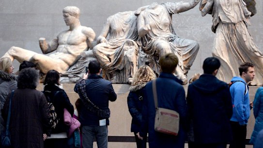 Visitors look at The Parthenon Marbles, also known as the Elgin Marbles in the British Museum.