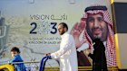 In this Wednesday, Feb. 5, 2020, photo, people walk past a banner showing Saudi Crown Prince Mohammed bin Salman, outside a mall in Jiddah, Saudi Arabia. Human rights organization Amnesty International says Saudi Arabia has used a special anti-terrorism court as "a weapon of repression" to imprison peaceful critics, dissidents, activists, journalists, clerics and members of the kingdom's minority Muslim Shiites, including some who were sentenced to death and executed. (AP Photo/Amr Nabil)