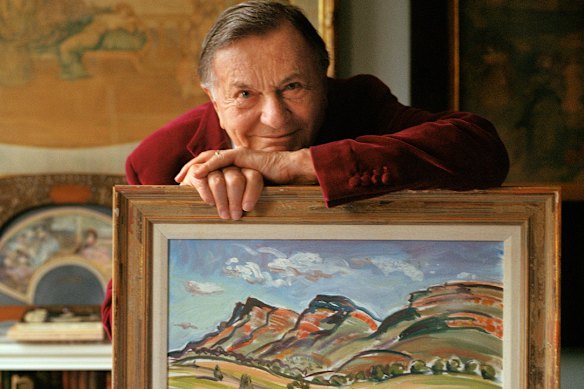 Barry Humphries in 2021 with his landscape painting of Wilpena, South Australia.