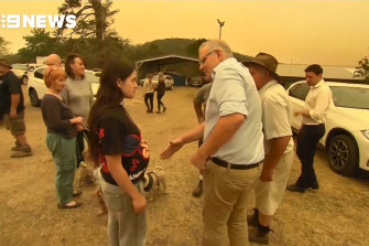 Prime Minister Scott Morrison tries to shake hands with a resident in fire-devastated Cobargo in January 2020.