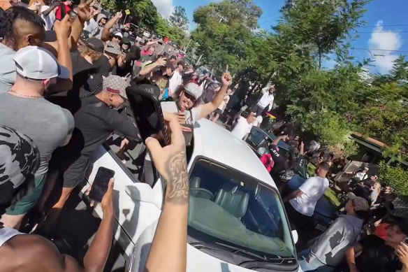 Residents of Logan City surrounding a car during Spanian’s recent visit.