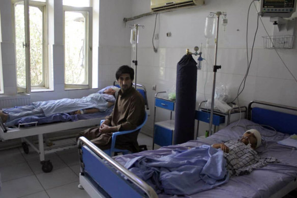 A wounded man and a young boy receive treatment in hospital after a fight between Taliban forces and Afghan security forces in Kunduz province on Saturday.