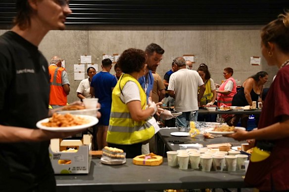 Le persone raccolgono cibo in un rifugio temporaneo a Bordeaux.