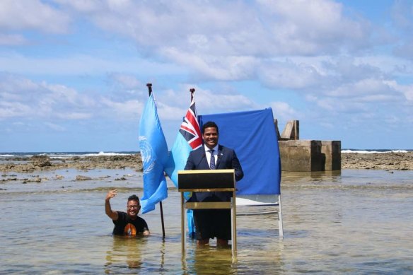 Tuvalu Foreign Affairs Minister Simon Kofe addresses COP26 standing in seawater that threatens his island nation.