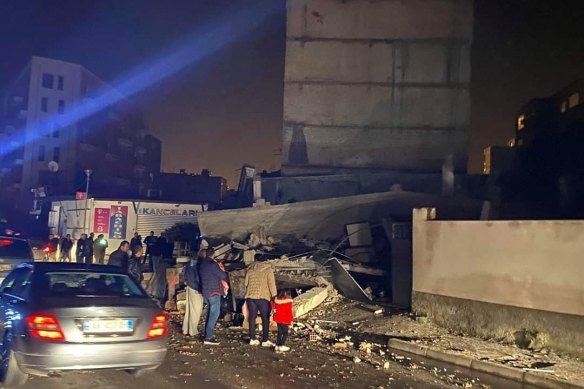 People look at a damaged building after an earthquake in Durres, western Albania on Tuesday.