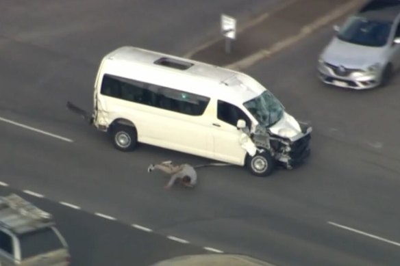 The driver lying on the road next to a van that was pursued by police.