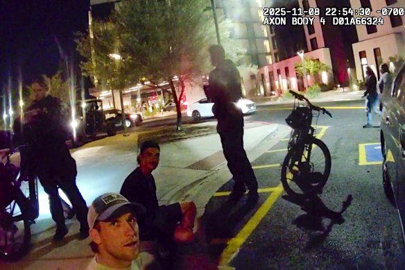 Dylan Moore (bottom left) and Connor Macdonald sit on the curb after their arrest in Scottsdale.