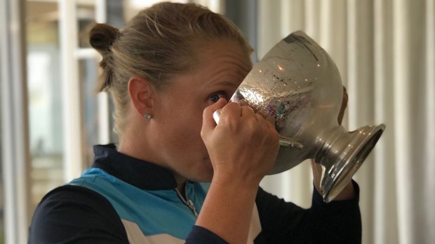 Healy takes a sip from the cup after victory at Sydney's Long Reef Golf Club.