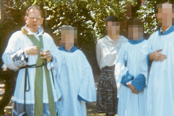 Father Ronald Pickering [L] with choir.