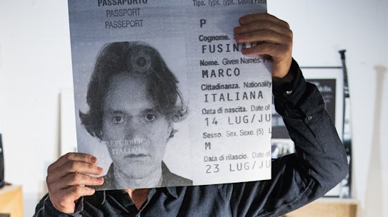 Marco Fusinato in his West Melbourne studio with a copy of his Italian passport picture.