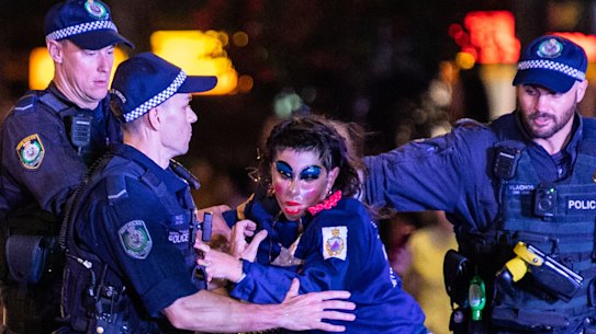 Police remove a protester fromthe parade route.