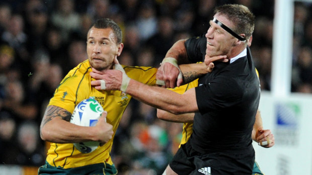 Quade Cooper fends of Brad Thorn who became the Queensland Reds coach and banished the 70-Test Wallaby from Super Rugby. 