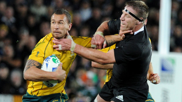 Quade Cooper fends off All Blacks legend Brad Thorn, who later became the Queensland Reds coach and banished the 70-Test Wallaby from Super Rugby. 