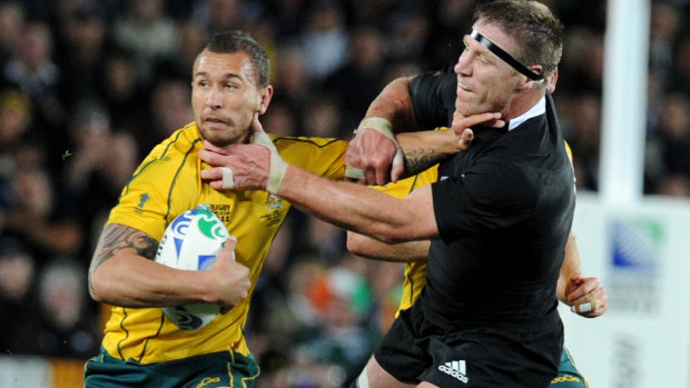 Quade Cooper fends off Thorn at the 2011 Rugby World Cup. 