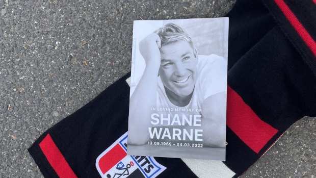 A funeral booklet and St Kilda flag at Shane Warne’s private funeral, held on Sunday. 